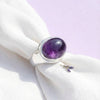 [KI] Silberring mit Amethyst auf hellem Stoff
