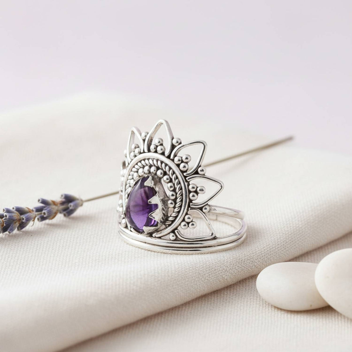 Silberring mit Amethyst auf hellem Stoff