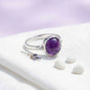 [KI] Silberring mit Amethyst auf hellem Stoff