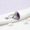 [KI] Silberring mit Amethyst auf hellem Stoff