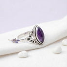 [KI] Silberring mit Amethyst auf hellem Stoff