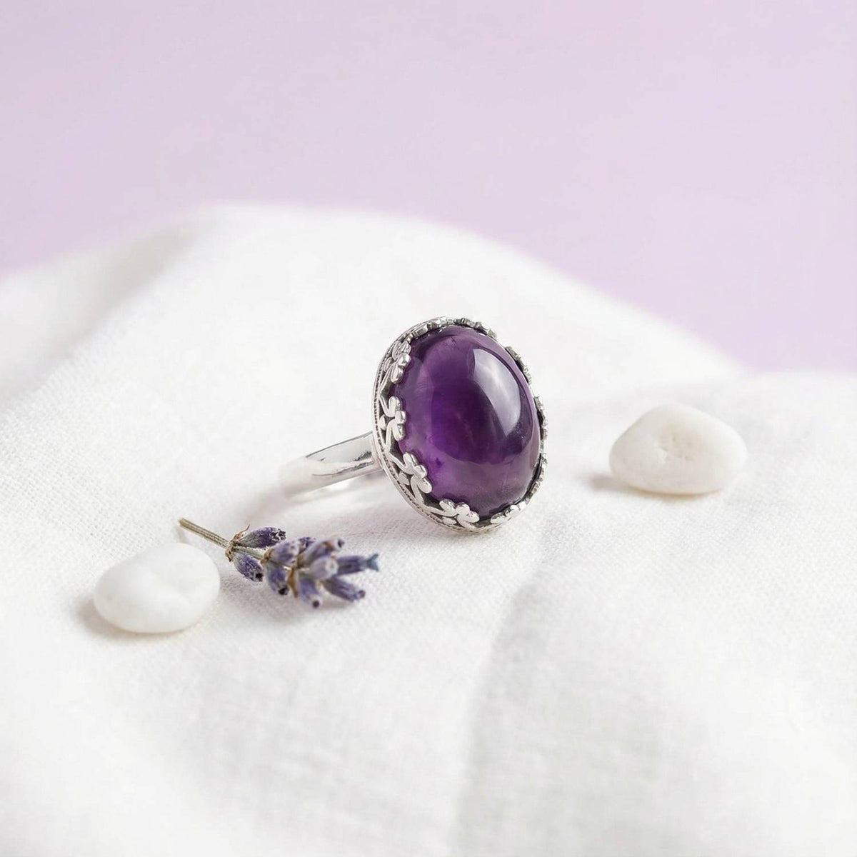 Silberring mit Amethyst auf hellem Stoff