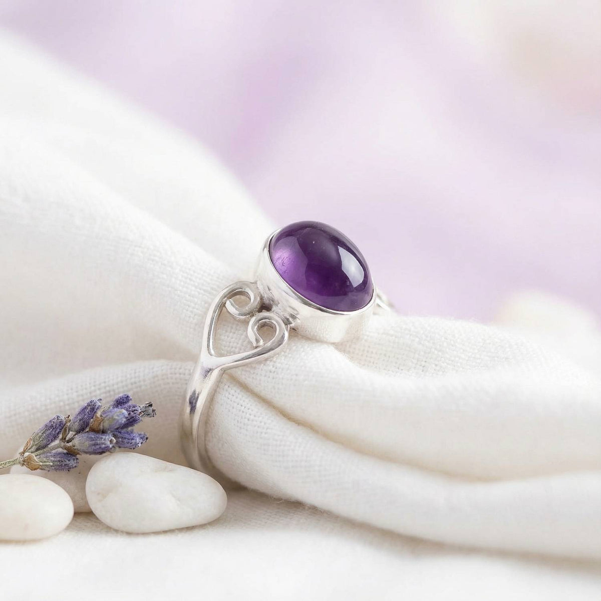 Silberring mit Amethyst auf hellem Stoff