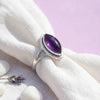 [KI] Silberring mit Amethyst auf hellem Stoff