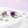[KI] Silberring mit Amethyst auf hellem Stoff