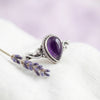 [KI] Silberring mit Amethyst auf hellem Stoff