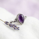 [KI] Silberring mit Amethyst auf hellem Stoff