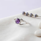 [KI] Silberring mit Amethyst auf hellem Stoff