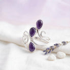 [KI] Silberring mit Amethyst auf hellem Stoff