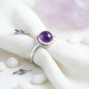 [KI] Silberring mit Amethyst auf hellem Stoff