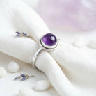 [KI] Silberring mit Amethyst auf hellem Stoff
