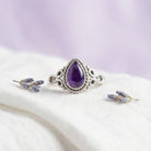 [KI] Silberring mit Amethyst auf hellem Stoff