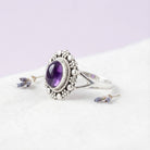 [KI] Silberring mit Amethyst auf hellem Stoff