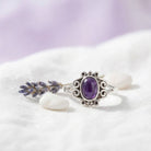 [KI] Silberring mit Amethyst auf hellem Stoff