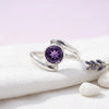 [KI] Silberring mit Amethyst auf hellem Stoff