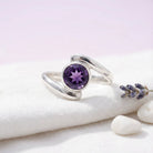 [KI] Silberring mit Amethyst auf hellem Stoff