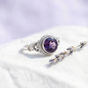 [KI] Silberring mit Amethyst auf hellem Stoff
