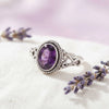[KI] Silberring mit Amethyst auf hellem Stoff
