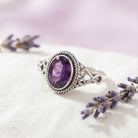 [KI] Silberring mit Amethyst auf hellem Stoff