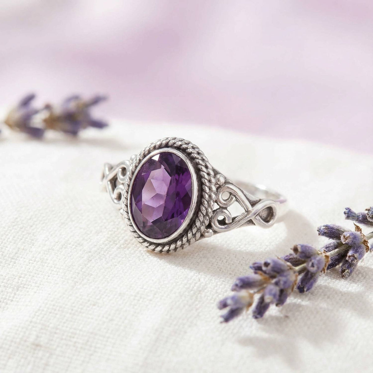 Silberring mit Amethyst auf hellem Stoff