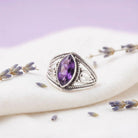 [KI] Silberring mit Amethyst auf hellem Stoff