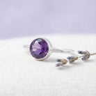 [KI] Silberring mit Amethyst auf hellem Stoff