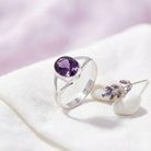 [KI] Silberring mit Amethyst auf hellem Stoff