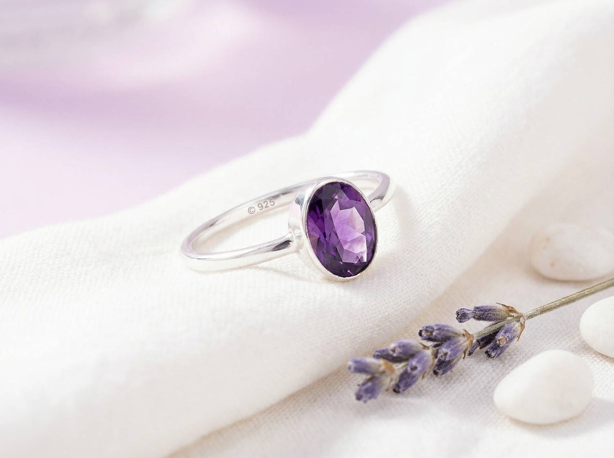 Silberring mit Amethyst auf hellem Stoff