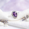 [KI] Silberring mit Amethyst auf hellem Stoff