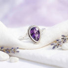 [KI] Silberring mit Amethyst auf hellem Stoff