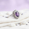 [KI] Silberring mit Amethyst auf hellem Stoff