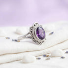 [KI] Silberring mit Amethyst auf hellem Stoff