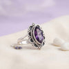 [KI] Silberring mit Amethyst auf hellem Stoff