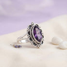 [KI] Silberring mit Amethyst auf hellem Stoff