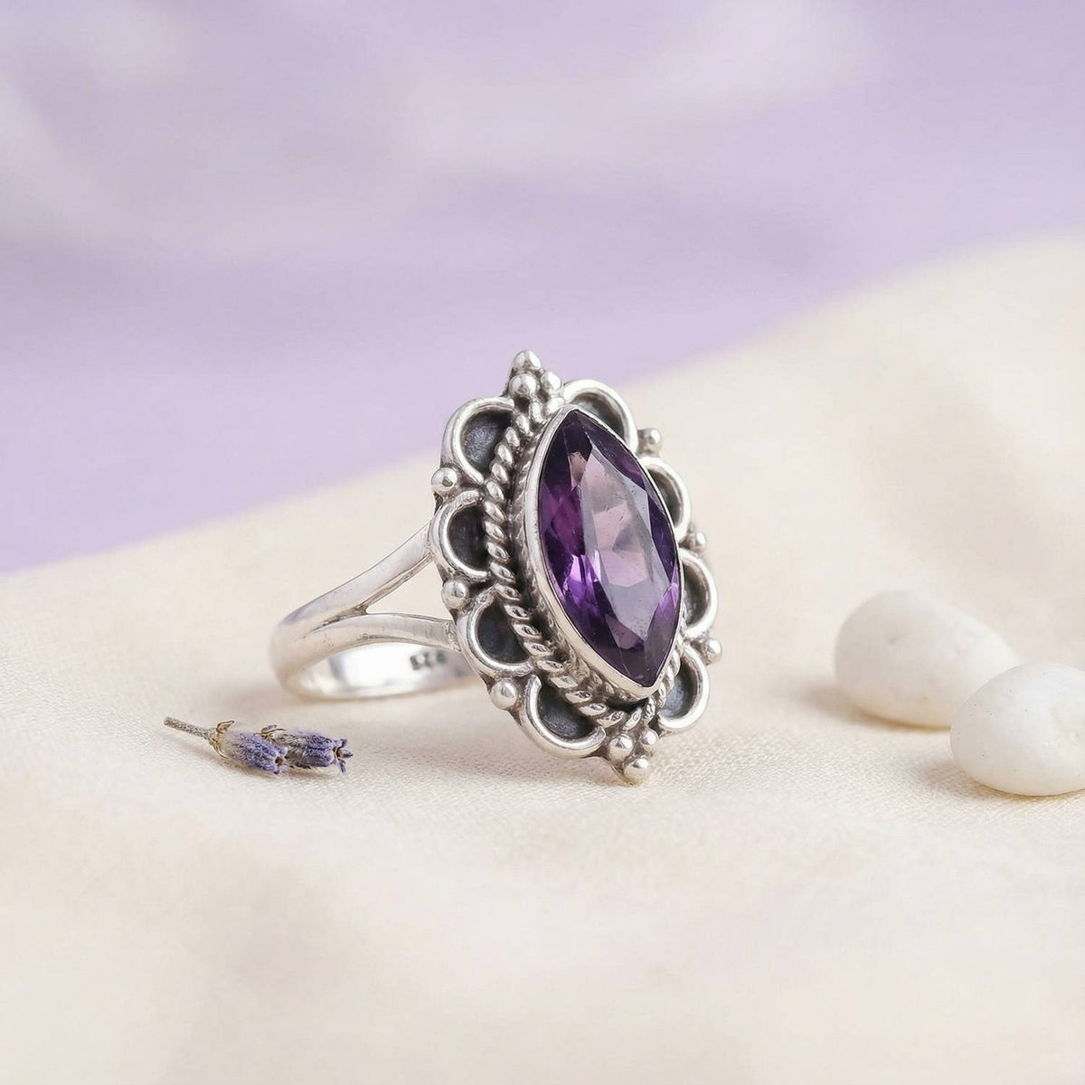 Silberring mit Amethyst auf hellem Stoff