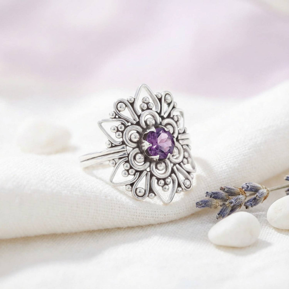 Silberring mit Amethyst auf hellem Stoff