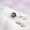 [KI] Silberring mit Amethyst auf hellem Stoff
