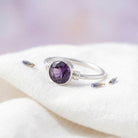[KI] Silberring mit Amethyst auf hellem Stoff