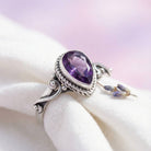 [KI] Silberring mit Amethyst auf hellem Stoff