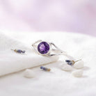 [KI] Silberring mit Amethyst auf hellem Stoff