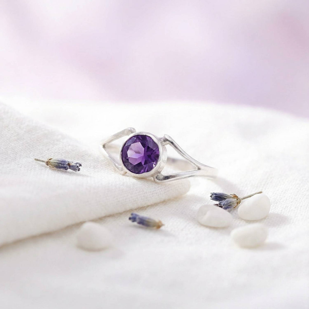 Silberring mit Amethyst auf hellem Stoff