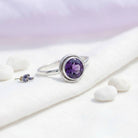[KI] Silberring mit Amethyst auf hellem Stoff