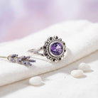 [KI] Silberring mit Amethyst auf hellem Stoff
