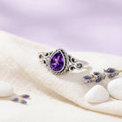 [KI] Silberring mit Amethyst auf hellem Stoff