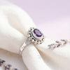 [KI] Silberring mit Amethyst auf hellem Stoff