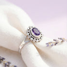 [KI] Silberring mit Amethyst auf hellem Stoff