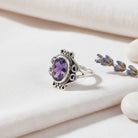 [KI] Silberring mit Amethyst auf hellem Stoff