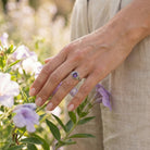 [KI] Silberring mit Amethyst an der Hand zwischen Blumen