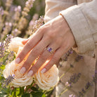 [KI] Silberring mit Amethyst an der Hand zwischen Blumen