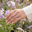 [KI] Silberring mit Amethyst an der Hand zwischen Blumen